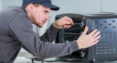 worker fixing electric microwave oven